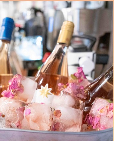Rosé bottles chilling in an ice bucket with floral ice cubes