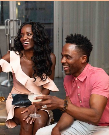 Two guests laughing over cocktails at a But, Is There Wine pop-up